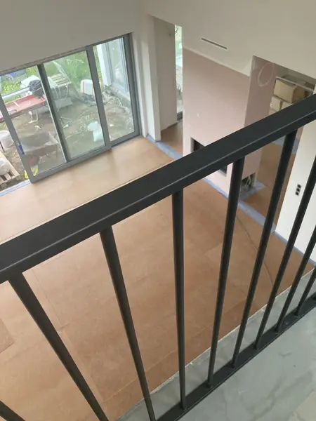 Wnętrze z dużymi oknami, drewnianą podłogą, nowoczesny styl i współczesny design.