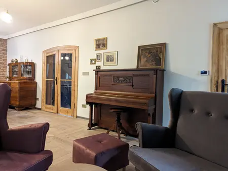 Wnętrze salonu w stylu boho i rustykalnym z fortepianem i drewnianymi meblami