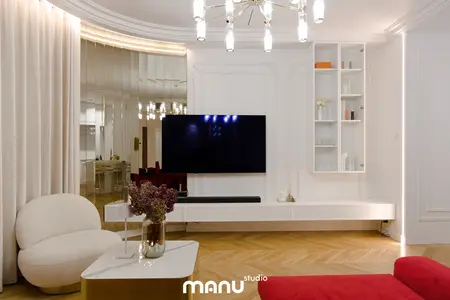 Wnętrze salonu z białymi meblami, nowoczesnymi akcentami i tradycyjnym oświetleniem.