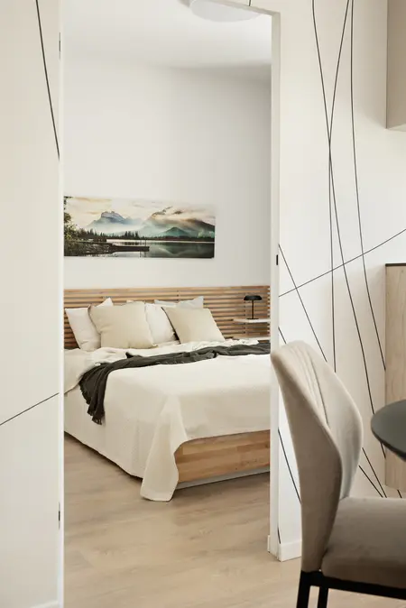 Wnętrze sypialni z minimalistycznym designem, nowoczesne meble i spokojna kolorystyka.