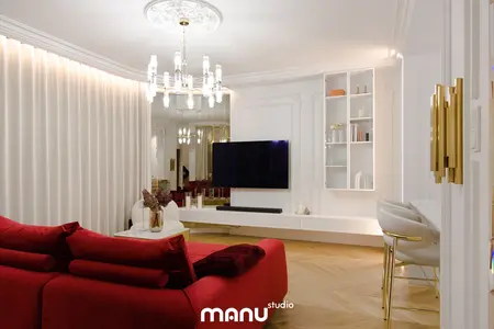 Wnętrze salonu z nowoczesnym oświetleniem, czerwonymi sofami i minimalistycznym wystrojem.