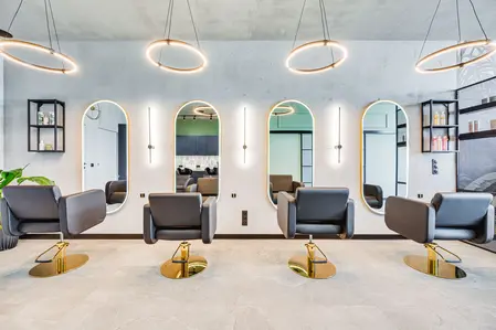 Wnętrze salonu fryzjerskiego z lustrami i nowoczesnym oświetleniem, styl industrialny i współczesny.