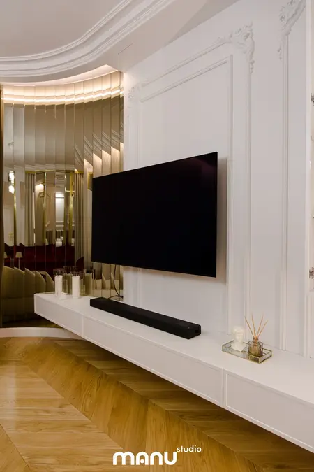 Wnętrze z telewizorem na białej półce, nowoczesne i tradycyjne elementy.
