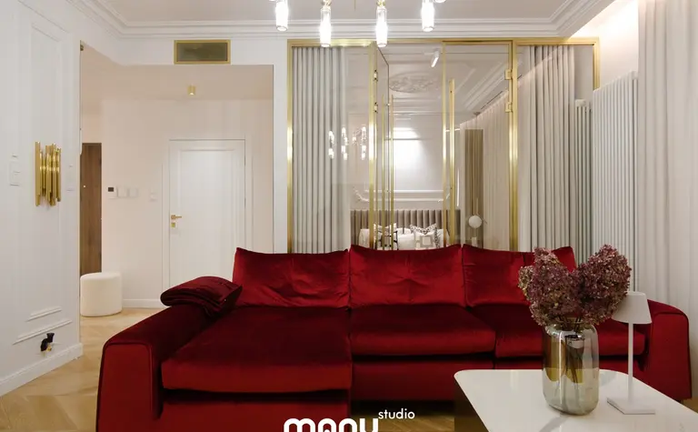 Wnętrze salonu z nowoczesną czerwoną sofą, białym stolikiem oraz elementami quiet luxury.