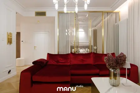Wnętrze salonu z nowoczesną czerwoną sofą, białym stolikiem oraz elementami quiet luxury.