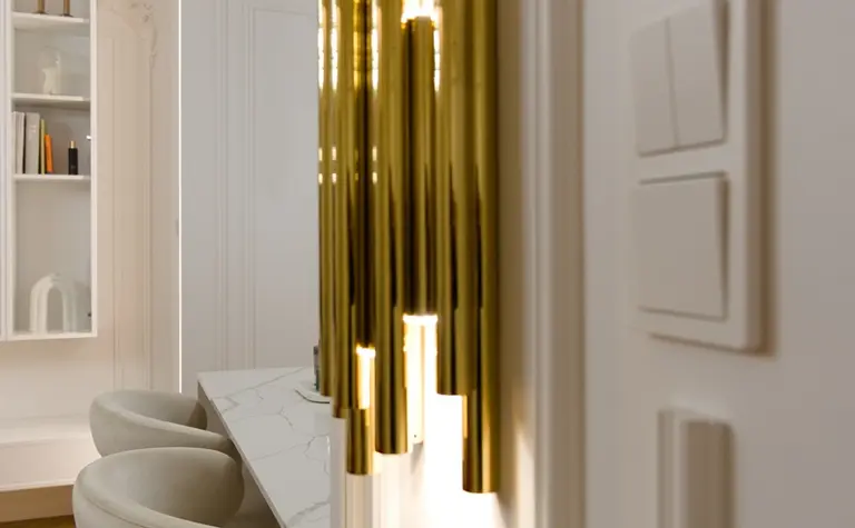 Złote oświetlenie w nowoczesnym wnętrzu z białymi meblami. Styl quiet luxury i tradycyjny.