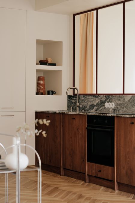 Kuchnia w stylu quiet luxury z drewnianymi meblami, minimalistycznym designem i vintage akcentami.