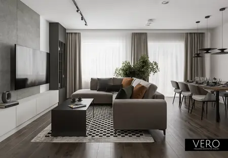 Wnętrze nowoczesnego salonu z minimalistycznym designem, szarymi meblami i zielonymi roślinami.