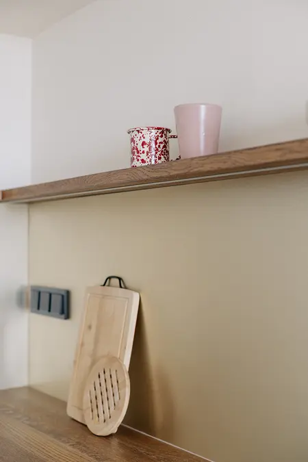 Minimalistyczna kuchnia z drewnianym blatem, nowoczesnymi naczyniami i skandynawskim akcentem.