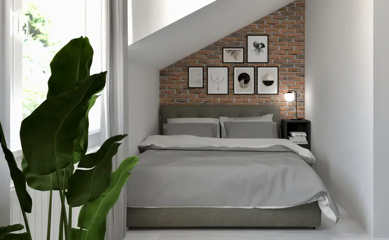 Sypialnia w stylu industrialnym i soft minimalizm z ceglaną ścianą i szarym łóżkiem.