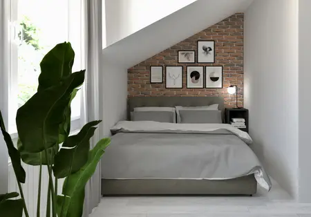 Sypialnia w stylu industrialnym i soft minimalizm z ceglaną ścianą i szarym łóżkiem.