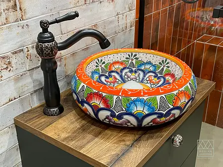 Umywalka w stylu eklektycznym z kolorowymi motywami na tle drewnianego blatu.