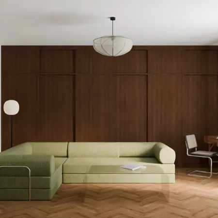 Wnętrze salonu w stylu vintage z zieloną sofą i drewnianą podłogą.