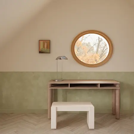Wnętrze poddasza z drewnianym biurkiem, minimalistycznym lampą i okrągłym oknem.