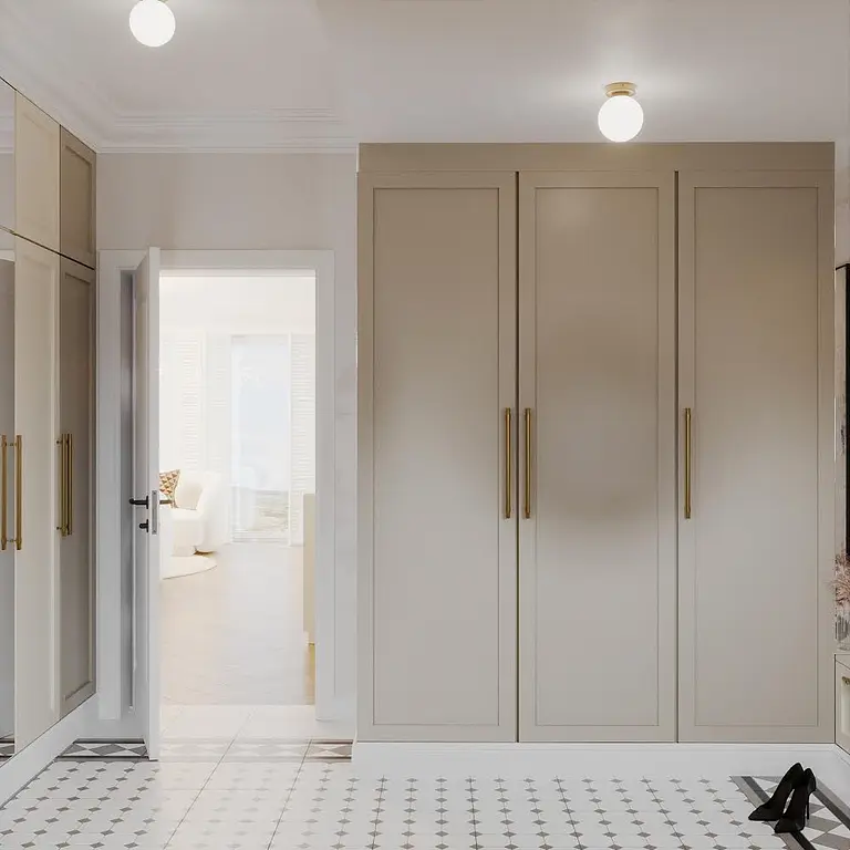 Garderoba w stylu art deco i eklektycznym, z beżowymi szafami i dużym lustrem.