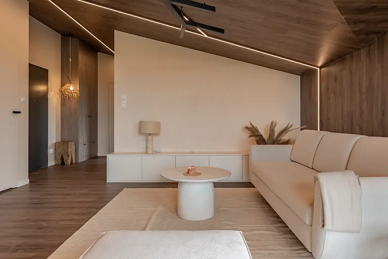 Wnętrze salonu w stylu boho i japandi z beżową sofą.