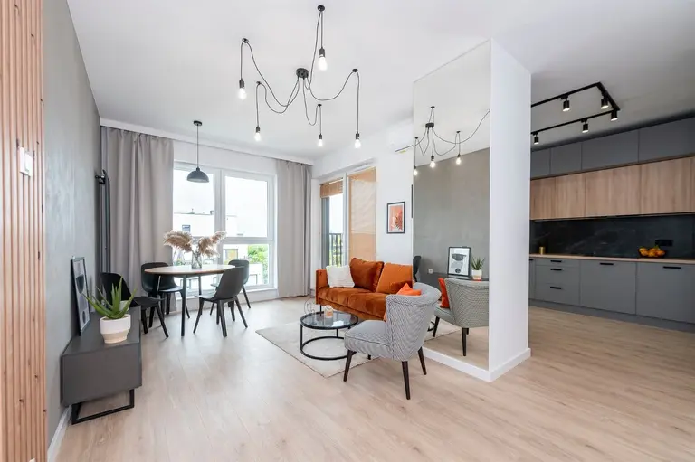 Wnętrze salonu w stylu industrialnym i minimalistycznym z brązową kanapą.