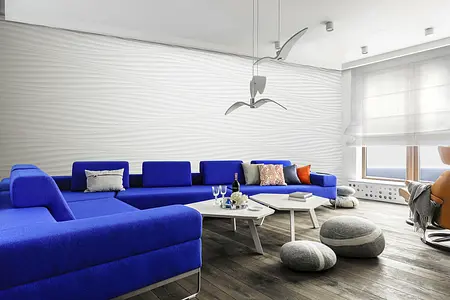 Wnętrze salonu w stylu skandynawskim z niebieską sofą i jasnymi dodatkami.
