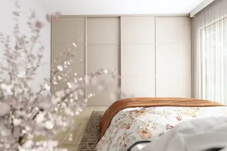 Sypialnia z beżowymi meblami, kwiecistą pościelą i minimalistycznym stylem