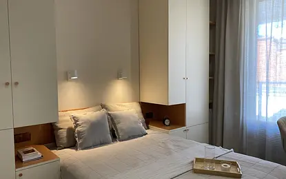 Sypialnia w stylu japandi z minimalistycznymi meblami i skandynawskim oświetleniem.