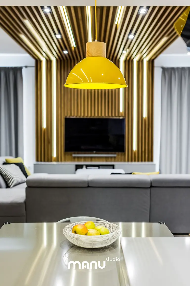 Salon w stylu industrialnym z minimalistycznym oświetleniem i drewnianą dekoracją.