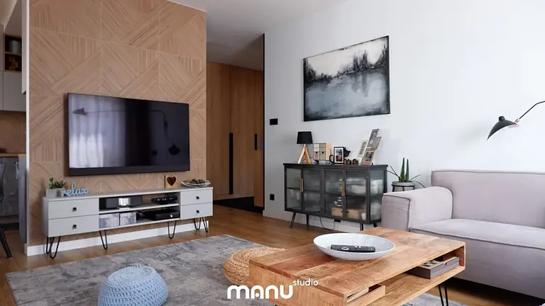 Wnętrze salonu z nowoczesnym telewizorem i skandynawskim stołem.