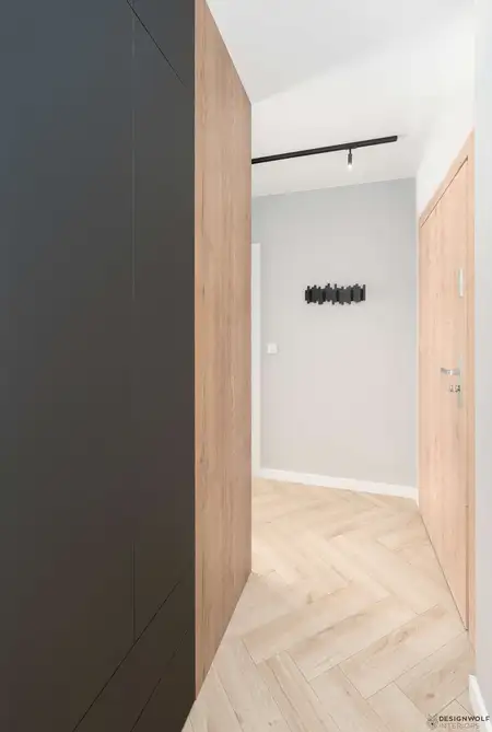 Korytarz w stylu industrialnym z drewnianymi ścianami i czarnymi detalami