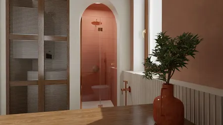 Wnętrze łazienki z różowymi płytkami, drewnianym blatem i rośliną.