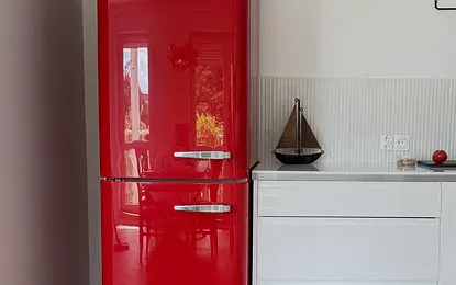 Eklektyczne wnętrze kuchni z czerwonym lodówką SMEG i białymi akcentami, quiet luxury